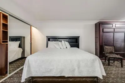 a bedroom with a large bed and a chair at Rodeway Inn Old Town Temecula in Temecula