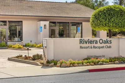 a building with a sign for the riviera oaks resort and favored club at Riviera Oaks Resort in Ramona