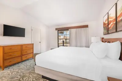 a bedroom with a white bed and a tv at Riviera Oaks Resort in Ramona