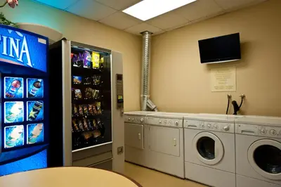 a laundry room with a washing machine and a tv at Club Wyndham Harbour Lights in San Diego
