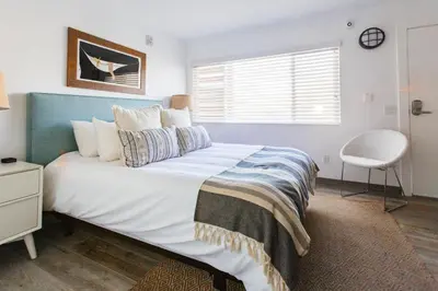 a bedroom with a large bed and a chair at Surfhouse in Encinitas