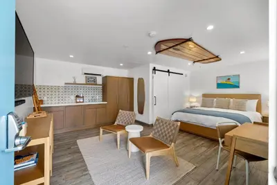 a bedroom with a bed and a desk and chairs at Surfhouse in Encinitas