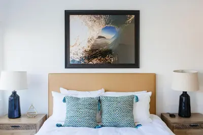 a bedroom with a bed with blue and white pillows at Surfhouse in Encinitas