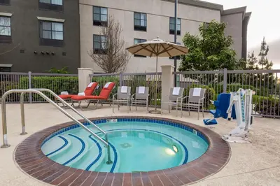 a small swimming pool with chairs and an umbrella at Hampton Inn & Suites San Diego-Poway in Poway