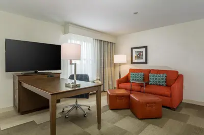 a hotel room with a desk and a couch and a television at Hampton Inn & Suites San Diego-Poway in Poway