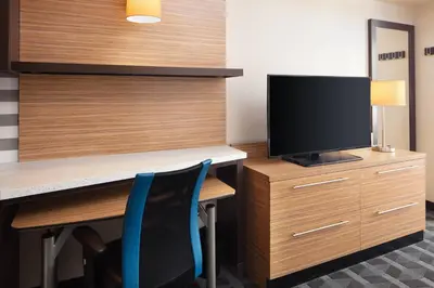 a room with a desk with a tv and a desk with chairs at TownePlace Suites by Marriott San Diego Downtown in San Diego