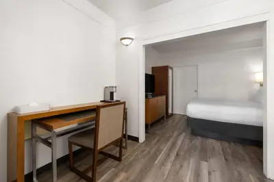 a hotel room with a bed and a desk at Ramada Suites by Wyndham San Diego Hotel Circle Area in San Diego