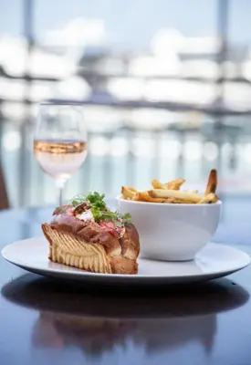 a sandwich and a bowl of fries and a glass of wine at Balboa Bay Resort in Newport Beach