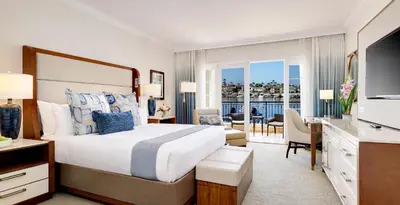 a bedroom with a large bed and a living room at Balboa Bay Resort in Newport Beach