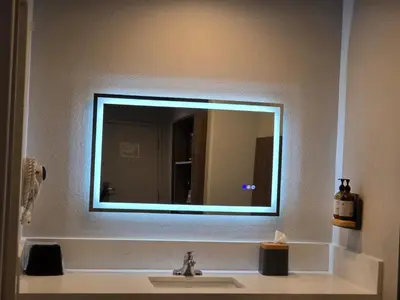 a bathroom sink with a large mirror above it at Hyland Inn near Legoland in Carlsbad