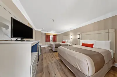 a hotel room with a large bed and a flat screen tv at Americas Best Value Inn San Clemente Beach in San Clemente