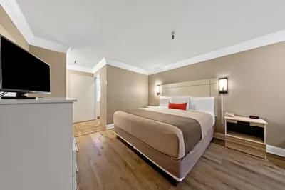 a bedroom with a large bed and a flat screen tv at Americas Best Value Inn San Clemente Beach in San Clemente