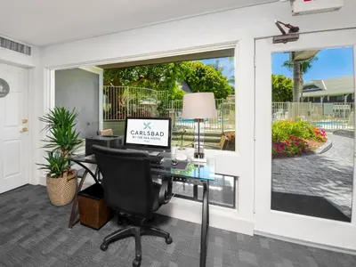 an office with a computer on a desk in front of a window at Carlsbad by the Sea Hotel in Carlsbad