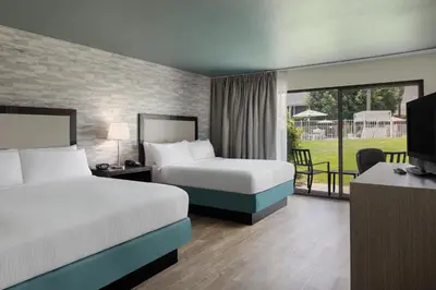 a hotel room with two beds and a television at Carlsbad by the Sea Hotel in Carlsbad