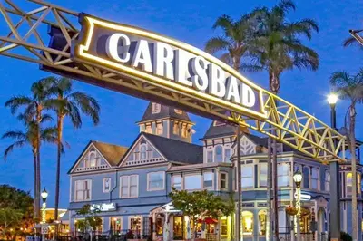 a sign in front of a large house at Carlsbad by the Sea Hotel in Carlsbad