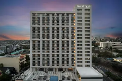 a tall white building with a pool in front of it at Courtyard by Marriott San Diego Downtown Little Italy in San Diego