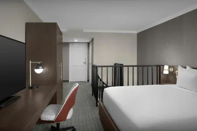 a bedroom with a bed and a desk and a chair at Courtyard by Marriott San Diego Downtown Little Italy in San Diego