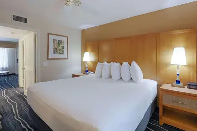 a hotel room with a large bed with white pillows at Ramada by Wyndham Costa Mesa/Newport Beach in Costa Mesa