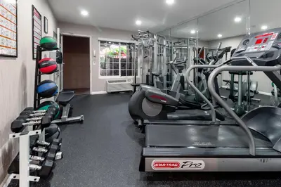 a gym with tread machines in a room at Ramada by Wyndham Costa Mesa/Newport Beach in Costa Mesa