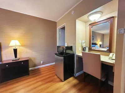 an empty room with a desk and a mirror at Royal Inn and Suites in Hemet