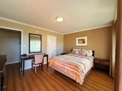 a bedroom with a bed and a table and a desk at Royal Inn and Suites in Hemet