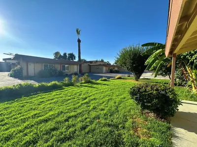 a yard of a house with a green lawn at Royal Inn and Suites in Hemet