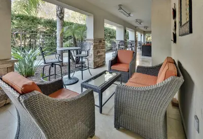 a patio with wicker chairs and a table and chairs at Hilton Garden Inn San Diego Del Mar in San Diego