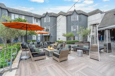 an outdoor patio with furniture and an orange umbrella at Hilton San Diego/Del Mar in San Diego