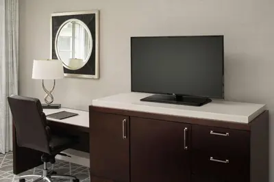 a hotel room with a desk with a television on it at Hilton San Diego/Del Mar in San Diego