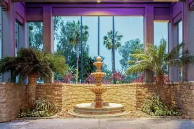 a fountain in front of a building with palm trees at Hilton San Diego/Del Mar in San Diego
