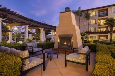 a patio with chairs and a fireplace in front of a building at Homewood Suites by Hilton San Diego Airport-Liberty Station in San Diego