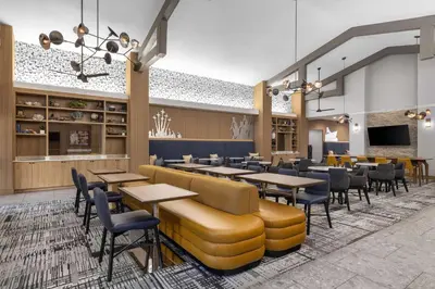 a rendering of a restaurant with tables and chairs at Homewood Suites by Hilton San Diego Airport-Liberty Station in San Diego