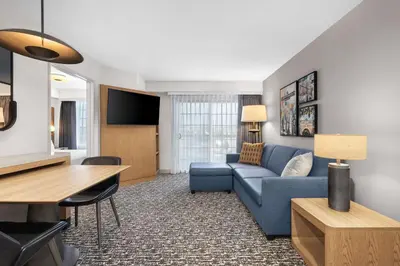 a living room with a blue couch and a tv at Homewood Suites by Hilton San Diego Airport-Liberty Station in San Diego
