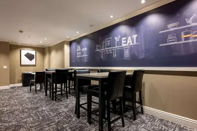 a dining room with tables and chairs against a wall at Hampton Inn by Hilton San Diego - Kearny Mesa in San Diego