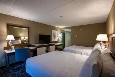 a hotel room with two beds and a desk and a mirror at Hampton Inn by Hilton San Diego - Kearny Mesa in San Diego