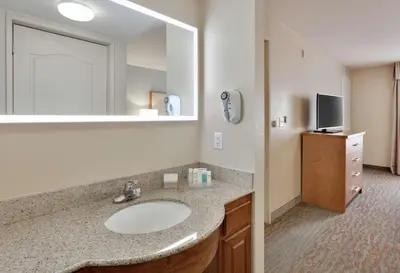 a bathroom with a sink and a large mirror at Homewood Suites by Hilton San Diego-Del Mar in San Diego