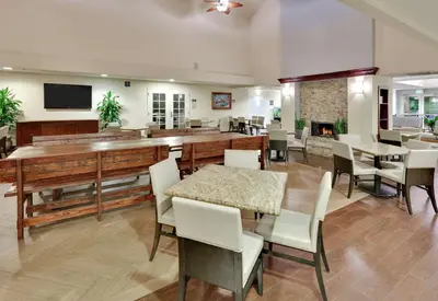 a dining room with a table and chairs and a fireplace at Homewood Suites by Hilton San Diego-Del Mar in San Diego
