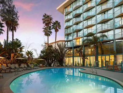 a hotel with a large swimming pool in front of a building at DoubleTree By Hilton San Diego Hotel Circle in San Diego