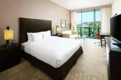 a hotel room with a large bed and a balcony at DoubleTree By Hilton San Diego Hotel Circle in San Diego