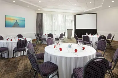 a conference room with tables and chairs and a screen at DoubleTree By Hilton San Diego Hotel Circle in San Diego