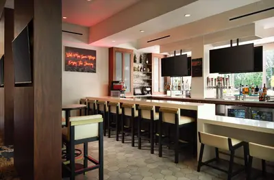 a bar with a row of bar stools at DoubleTree by Hilton San Diego Del Mar in San Diego