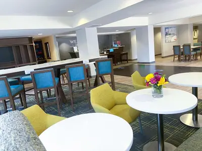 a hotel lobby with tables and chairs and flowers at Hampton Inn Carlsbad North San Diego County in Carlsbad