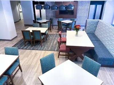 a restaurant with tables and chairs and flowers on tables at Hampton Inn Carlsbad North San Diego County in Carlsbad