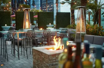 a fire pit in a patio with tables and chairs at Embassy Suites by Hilton San Diego La Jolla in San Diego