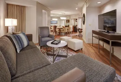 a living room with a couch and a piano at Embassy Suites by Hilton San Diego La Jolla in San Diego