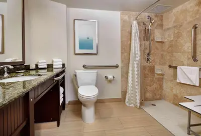 a bathroom with a toilet and a sink and a shower at Embassy Suites by Hilton San Diego La Jolla in San Diego