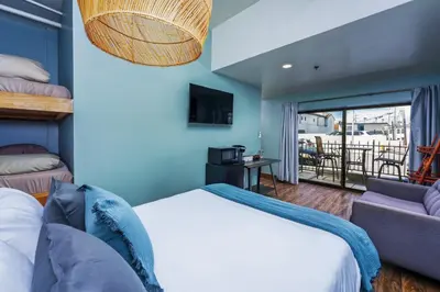 a bedroom with a bed and a couch and a balcony at Nomads Hotel in San Clemente