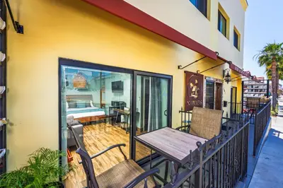 a balcony with a wooden table and chairs at Nomads Hotel in San Clemente