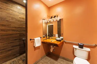 a bathroom with a sink and a toilet and a mirror at Nomads Hotel in San Clemente