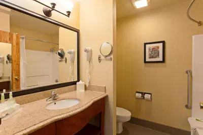 a bathroom with a sink and a mirror and a toilet at Holiday Inn Express Temecula by IHG in Temecula